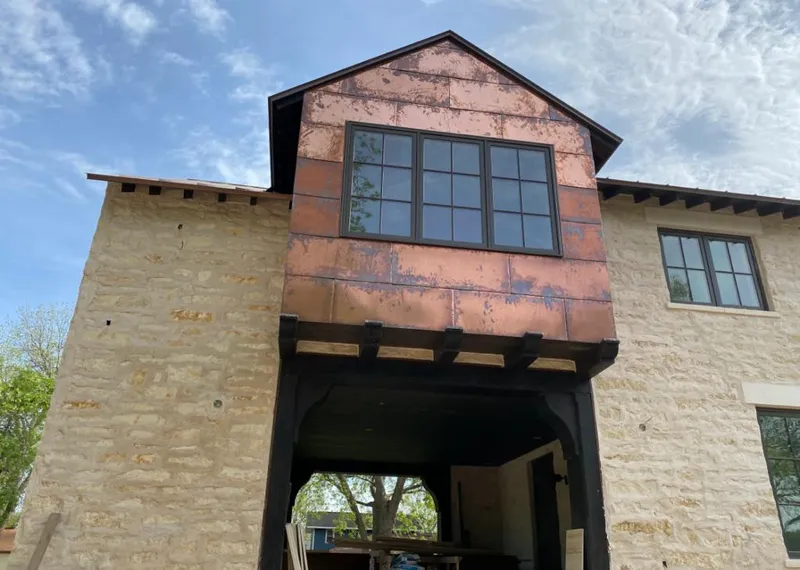 Copper metal panel facade on a stone building for Skylight Installation in Olive